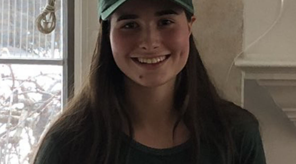 A girl wearing a green hat and shirt.